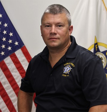 portait of Hal Phillips posing with American and FOP flags