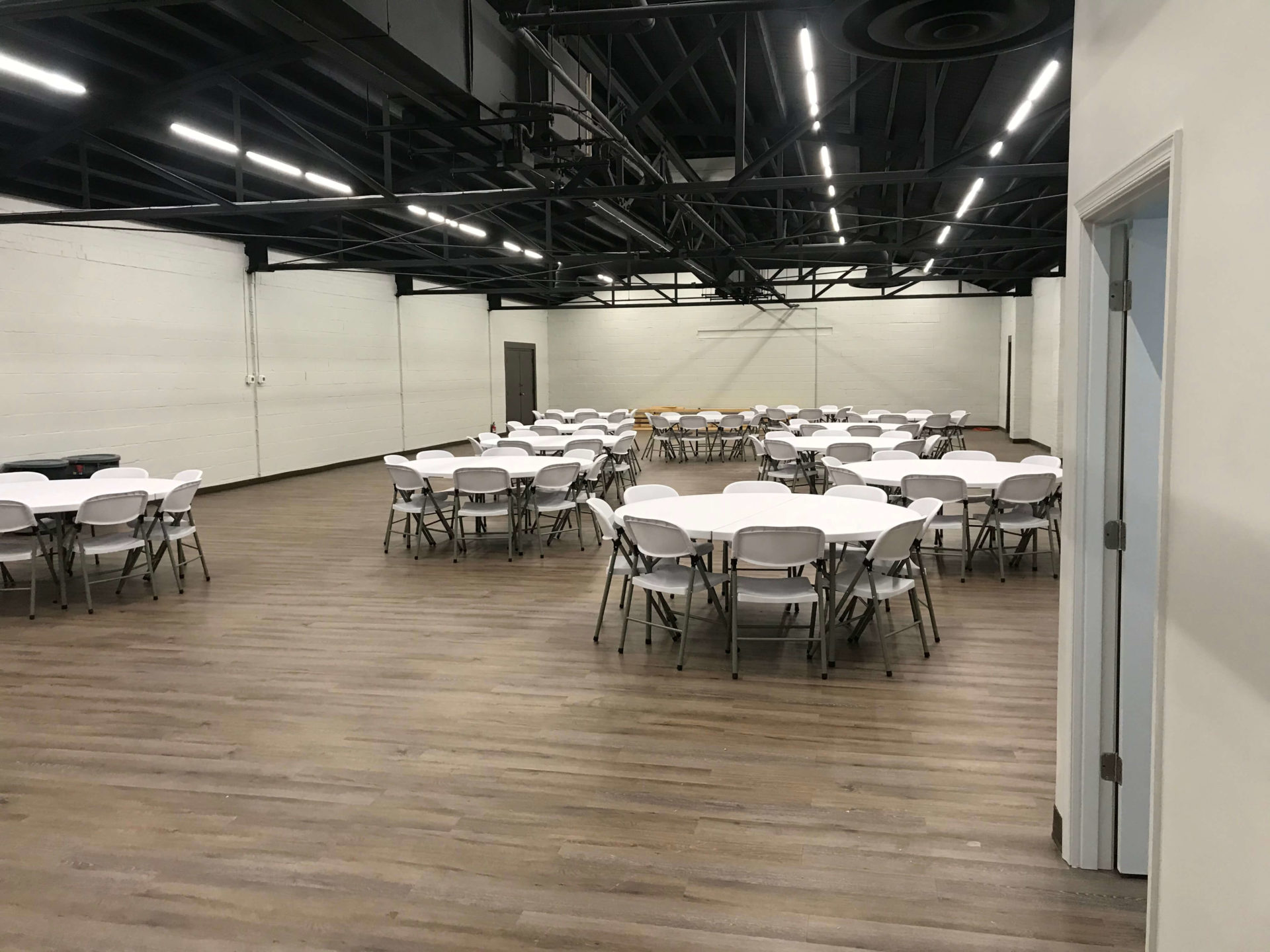 large meeting space with rounds of 8 tables setup